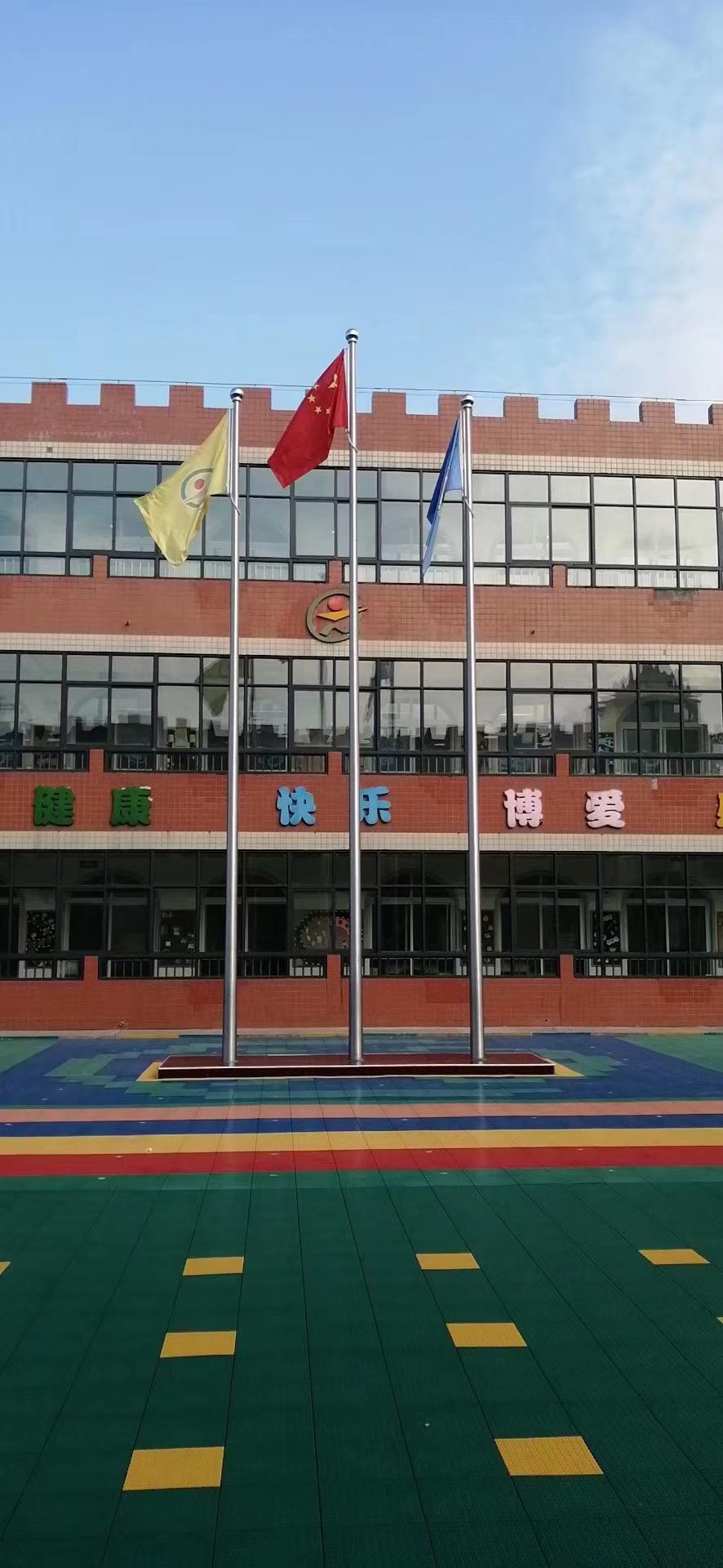 学校教学楼前三根旗杆与操场